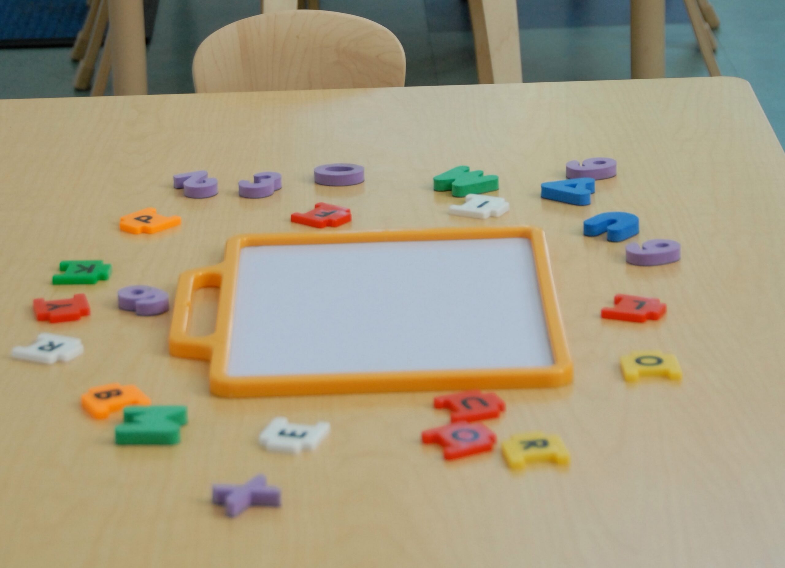 Childcare table with colorful alphabet magnets and board