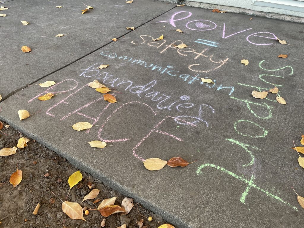 Chalk art messages against domestic violence on sidewalks by the YWCA